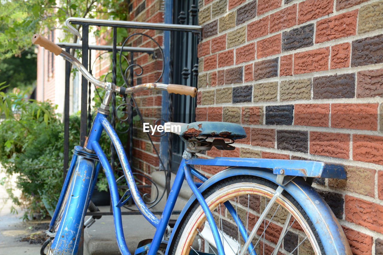 Blue bicycle leaning on wall