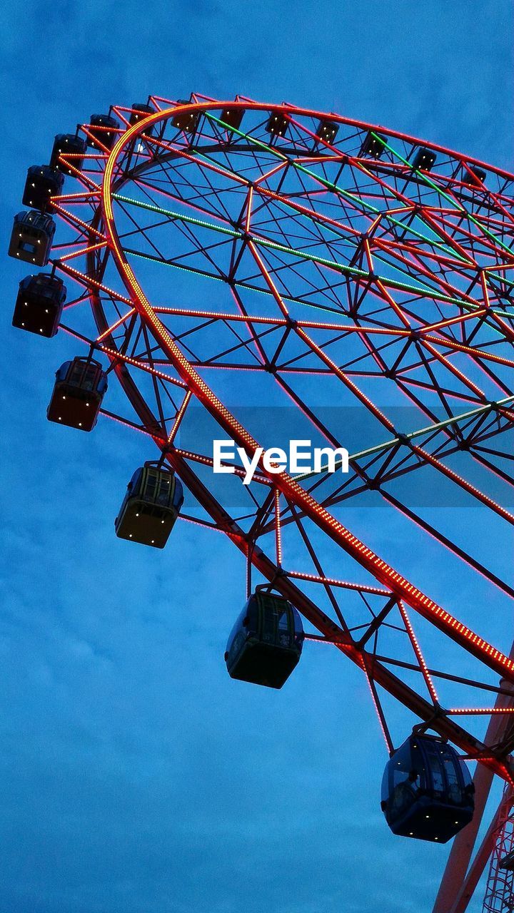 Low angle view of ferris wheel against blue sky