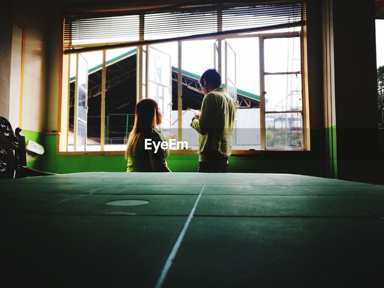 Man and woman standing against window