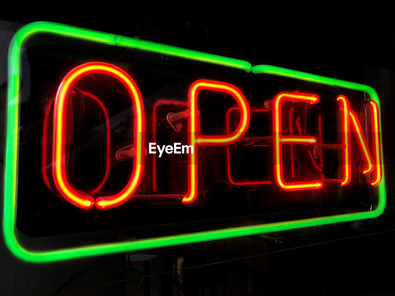 Open neon sign in shop or store window at night