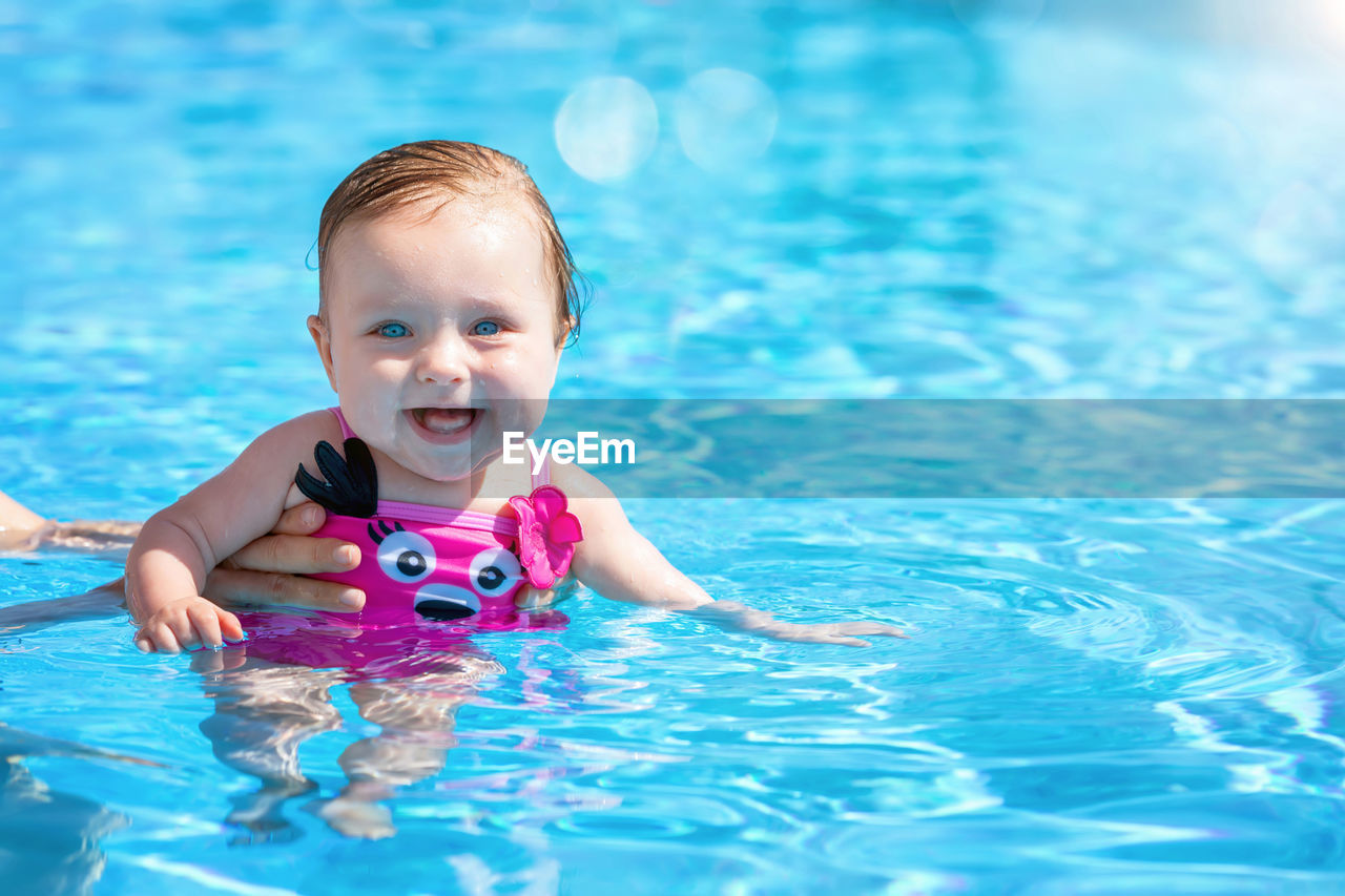 Portrait of cute baby girl in swimming pool