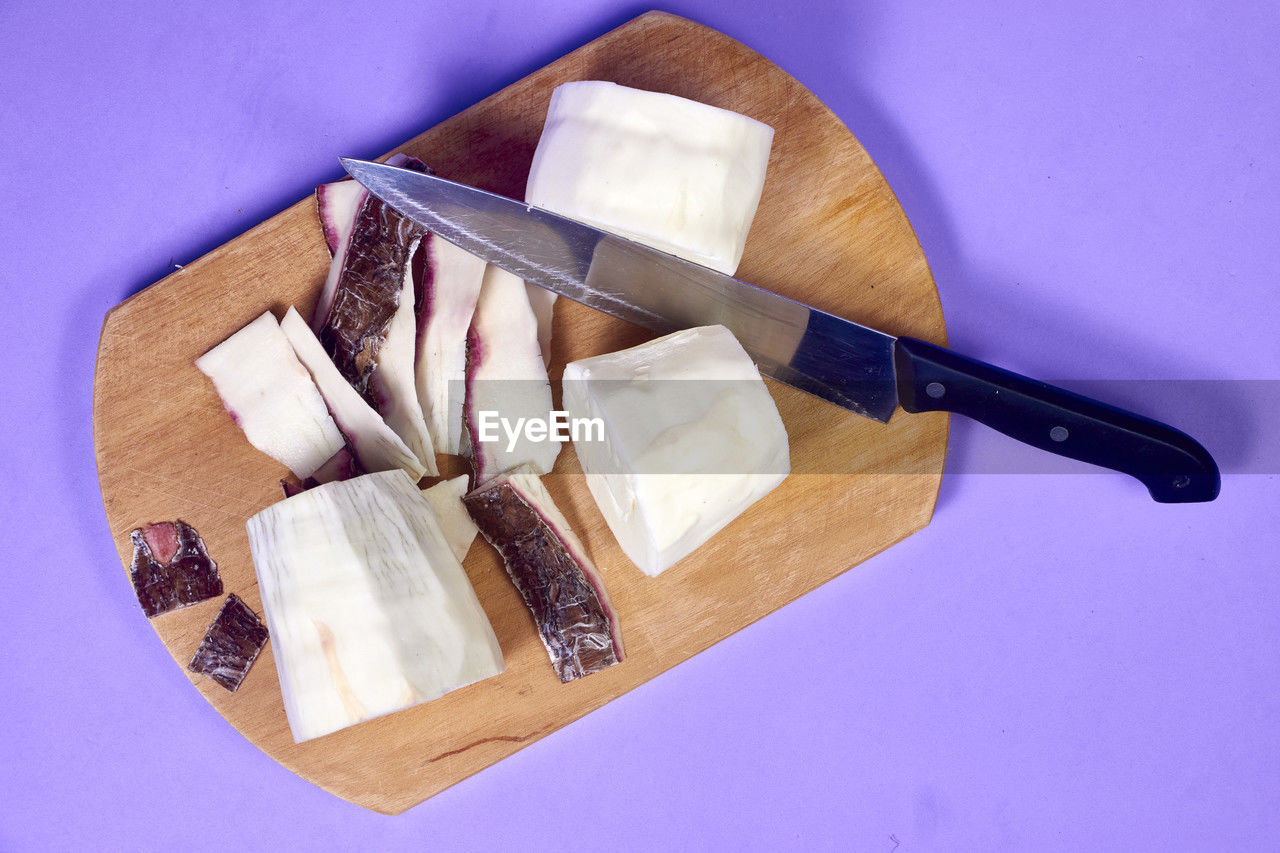 Fresh organic cassava root, manioc esculenta, yuca on purple background