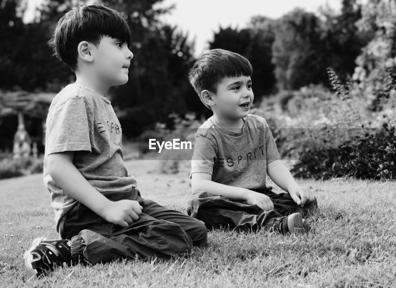 SIBLINGS SITTING ON GRASS