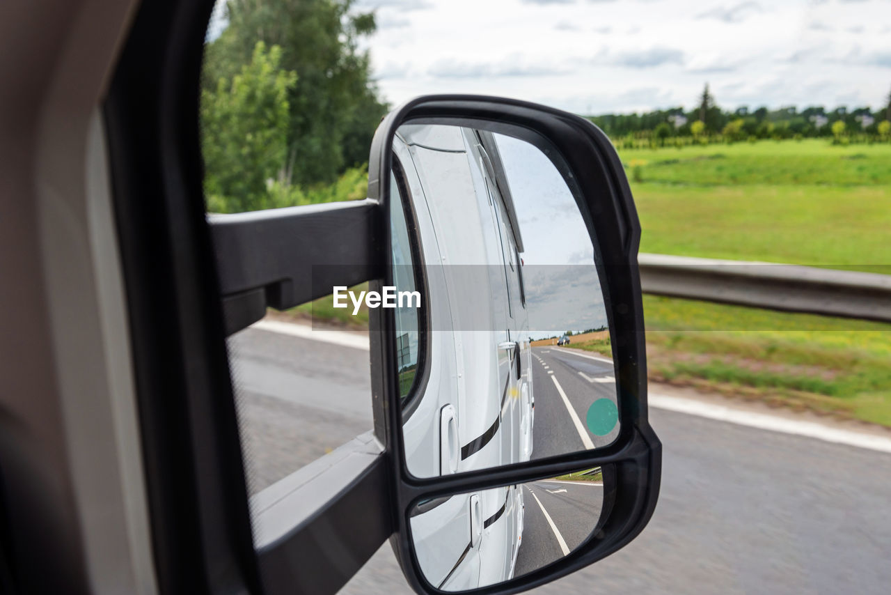 Road view from the side mirror. traveling by car