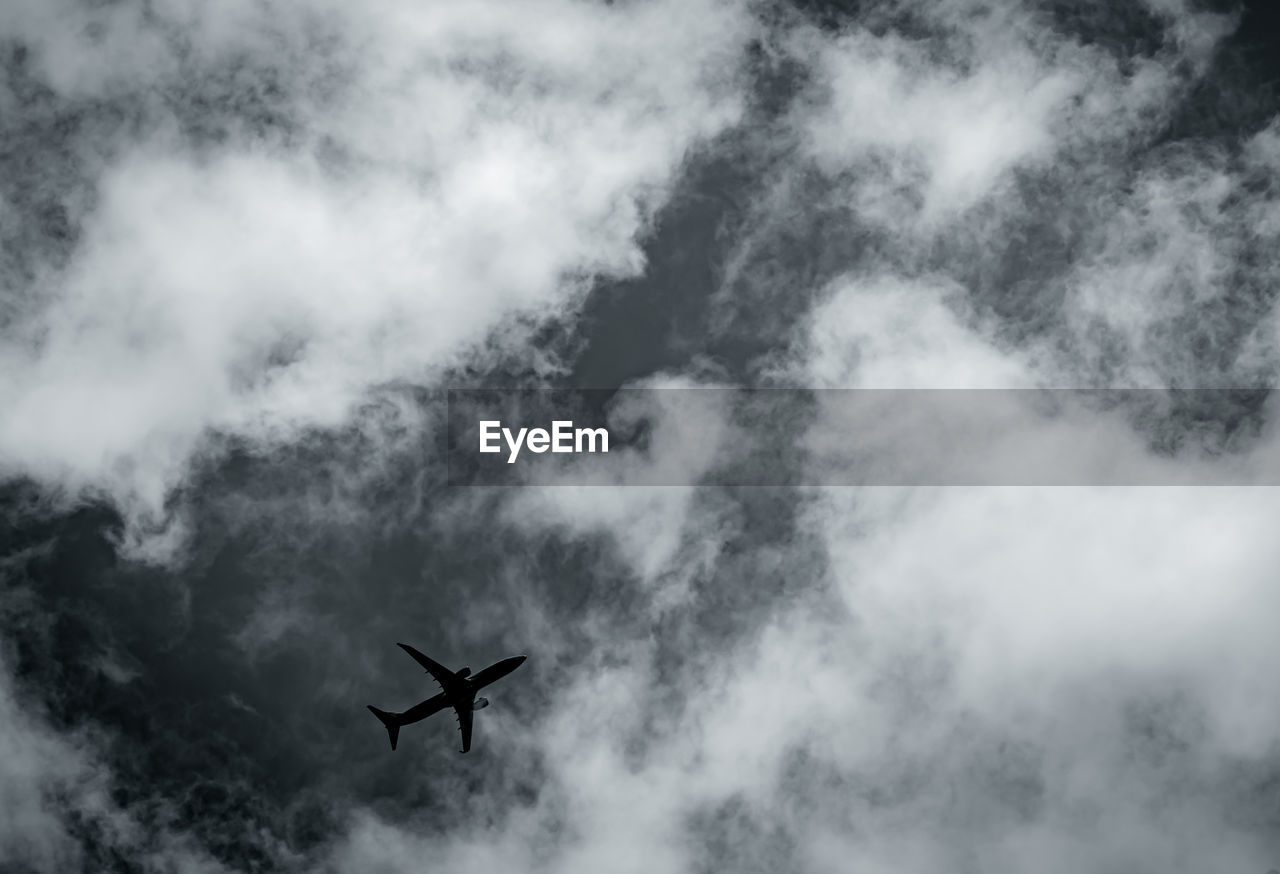 Commercial airplane on grey sky and clouds with copy space. failed vacation. hopeless and despair.