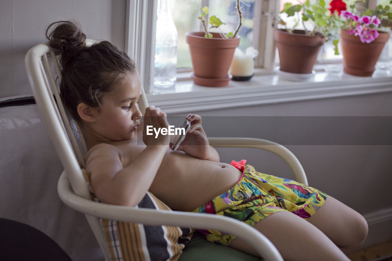 Girl on chair using cell phone