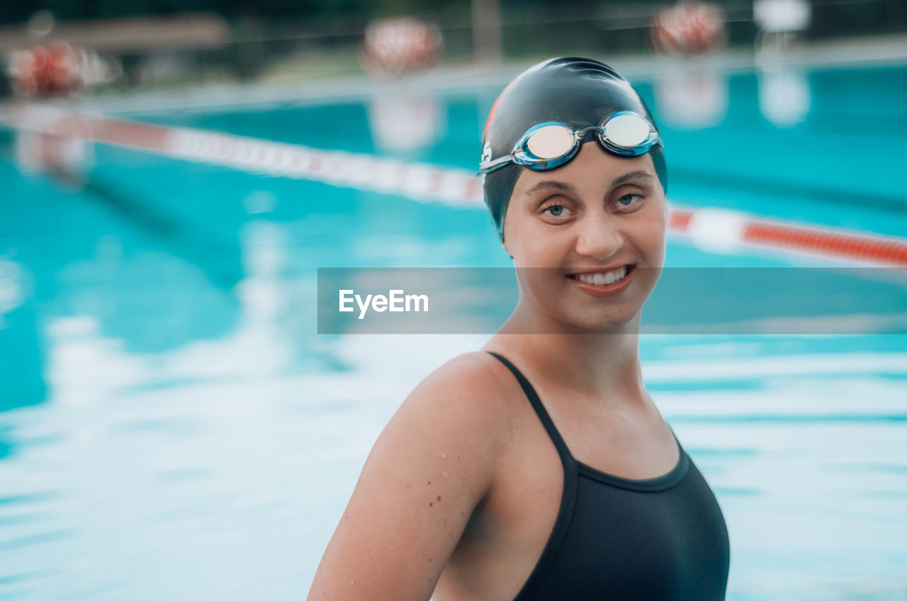 Portrait of smiling young woman in swimming in pool