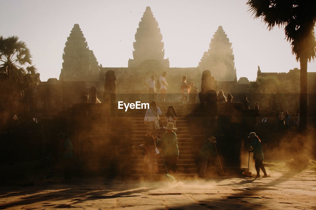 GROUP OF PEOPLE IN TEMPLE AGAINST BUILDING