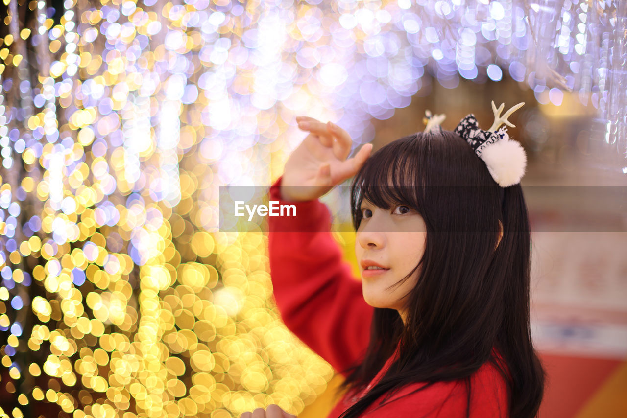 side view of woman looking away against christmas tree