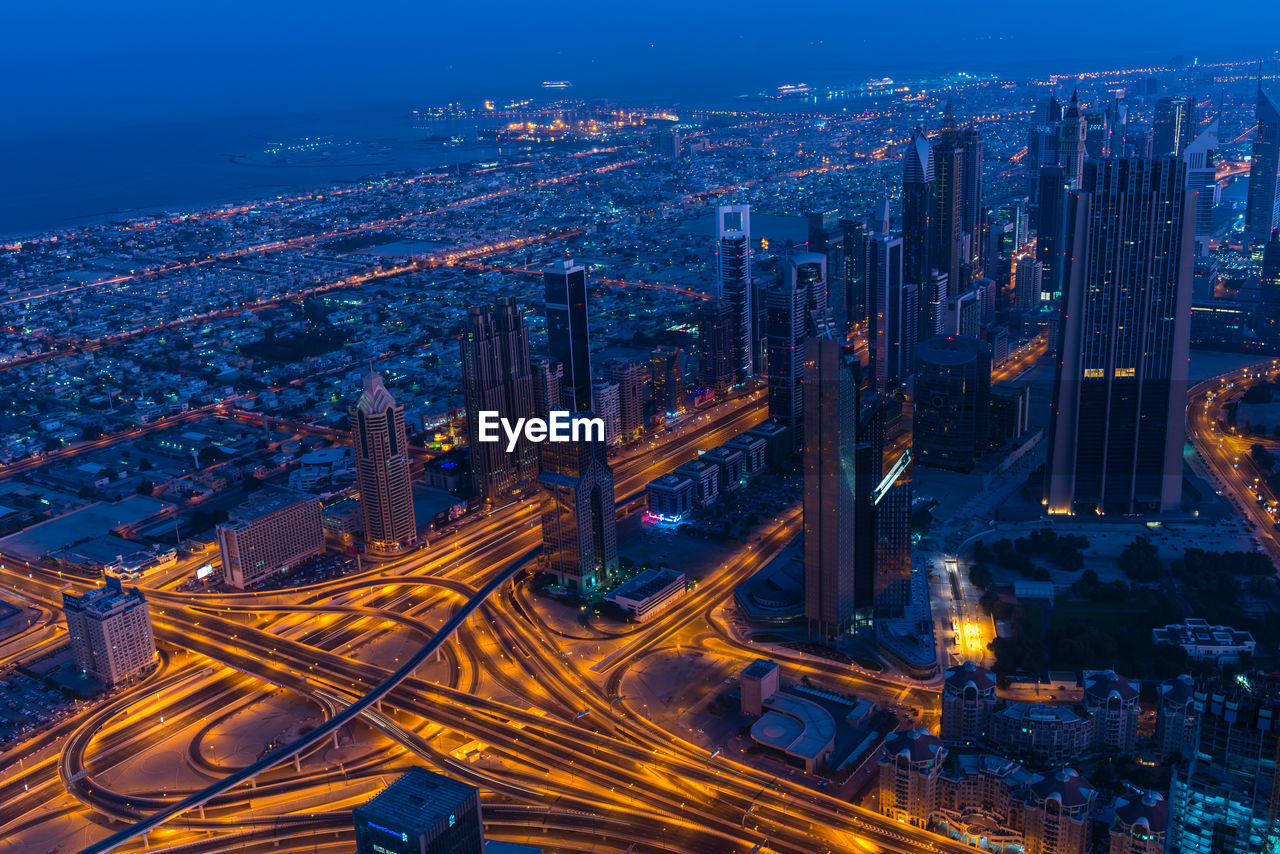 High angle view of illuminated city street and buildings at night