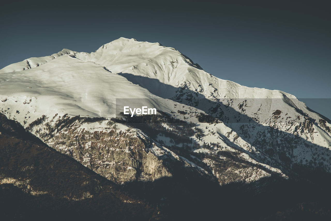 Scenic view of snowcapped mountains against clear sky