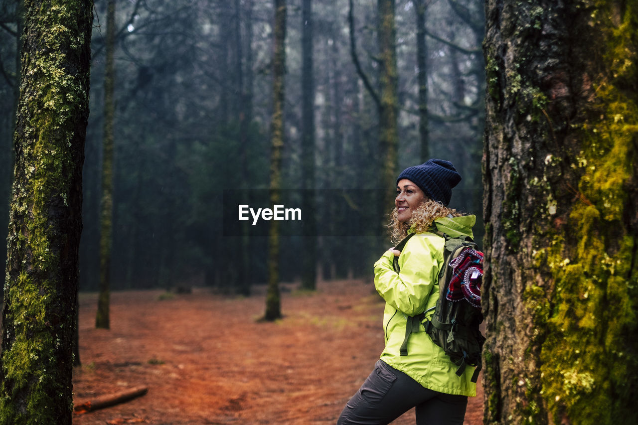 rear view of young woman standing in forest