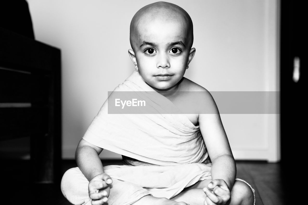 Portrait of boy wearing traditional clothing sitting at home