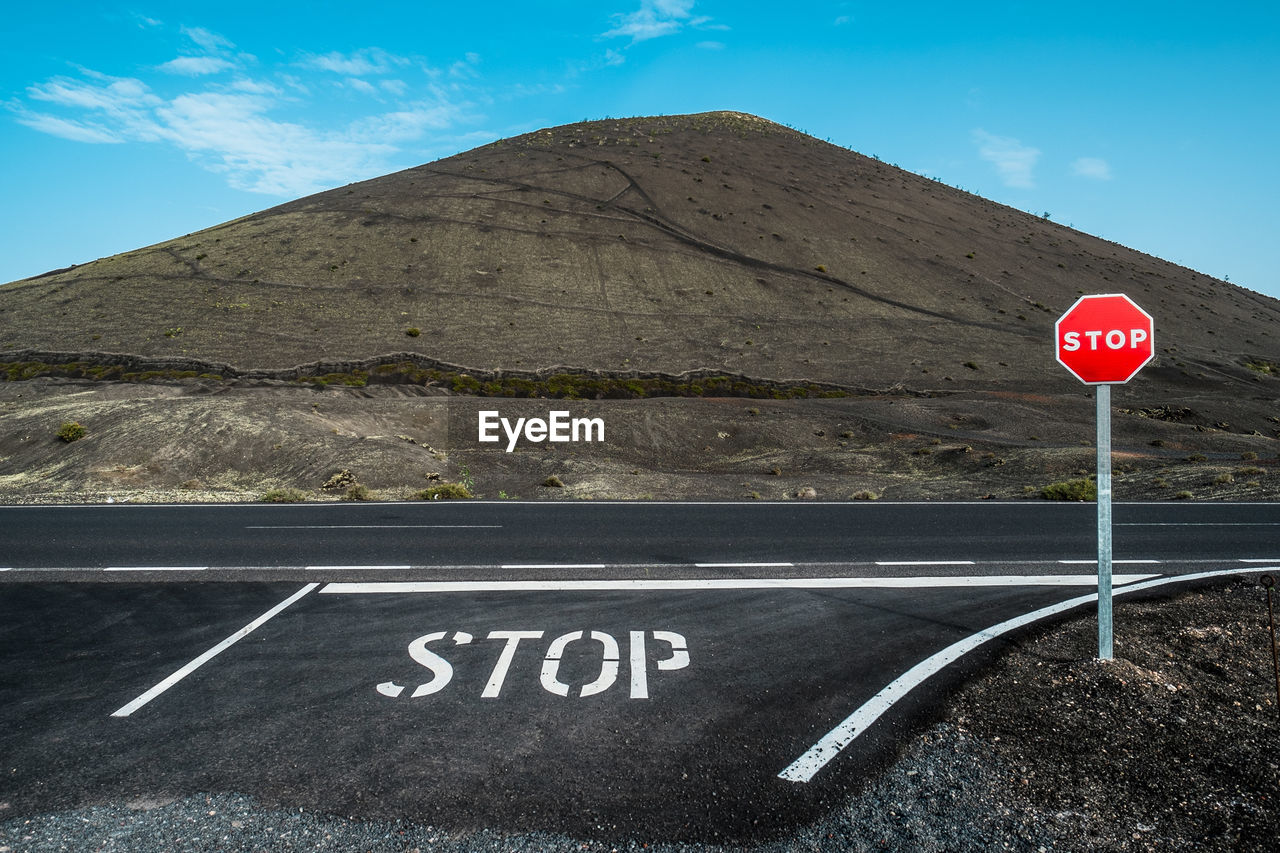 Close-up of road sign against cloudy sky