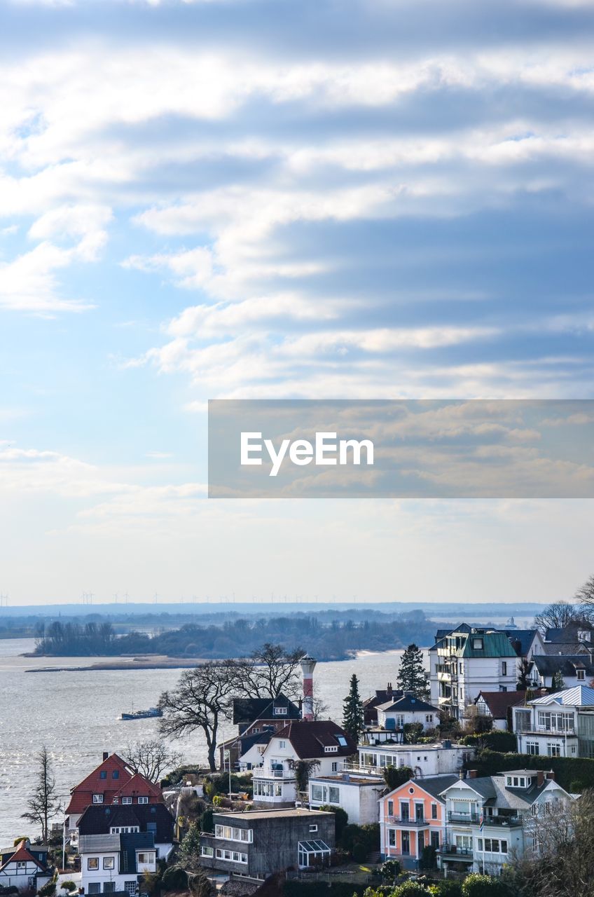 High angle view of houses by sea against sky