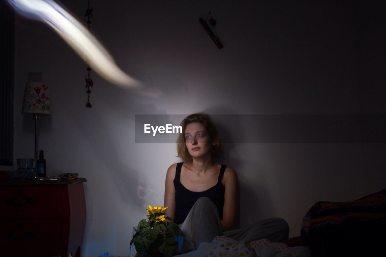 Thoughtful young woman sitting at home