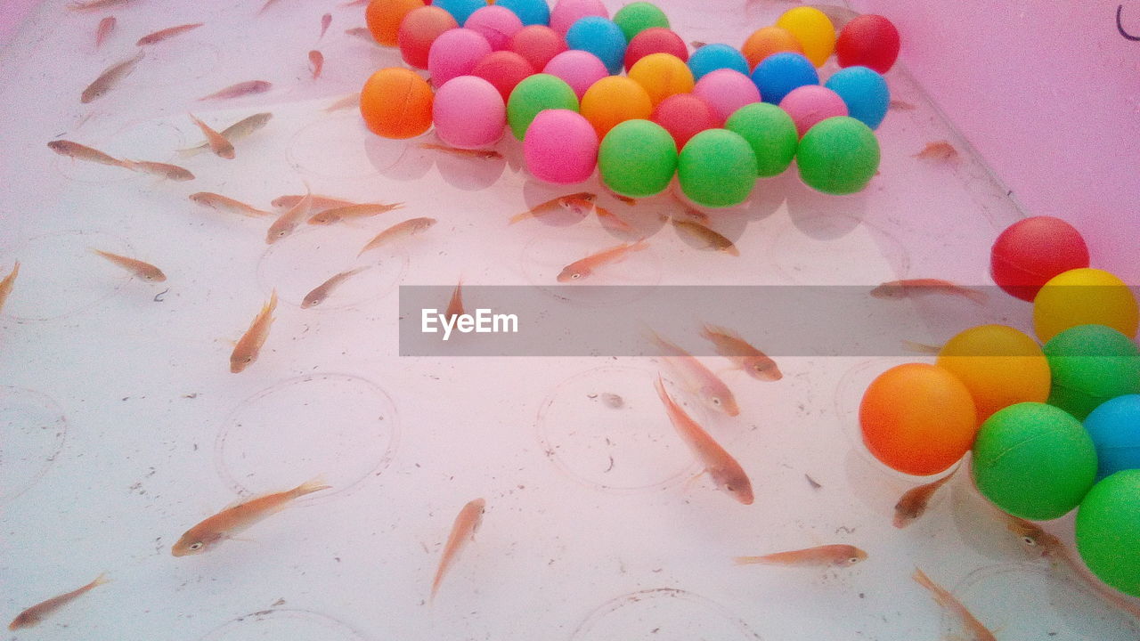 HIGH ANGLE VIEW OF MULTI COLORED BALLOONS IN CONTAINER