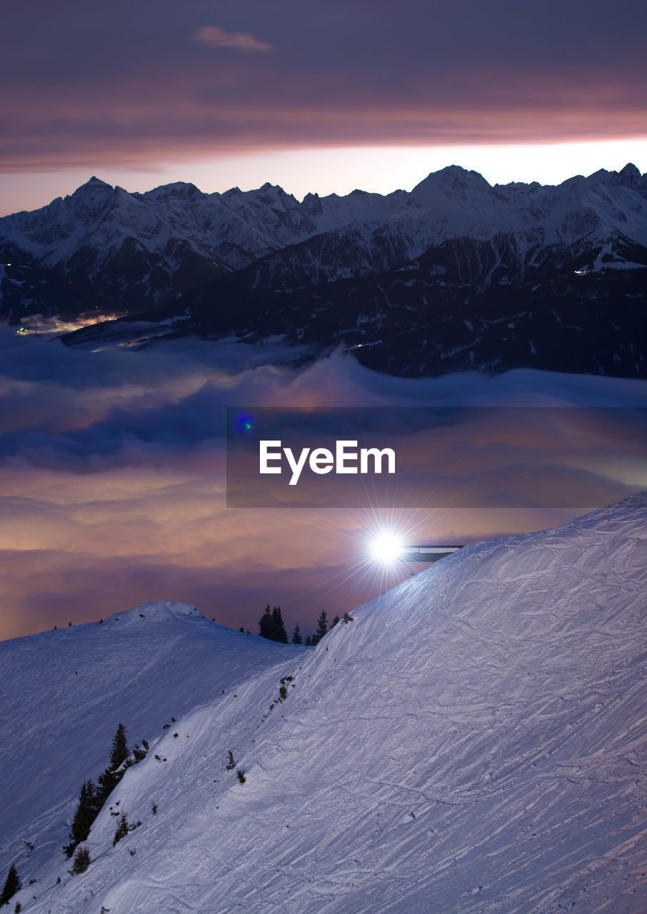 Scenic view of snow covered mountains against sky during sunset