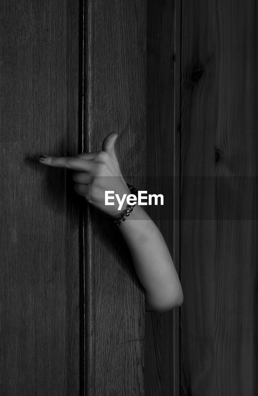 Close-up of hand obscene gesture on door