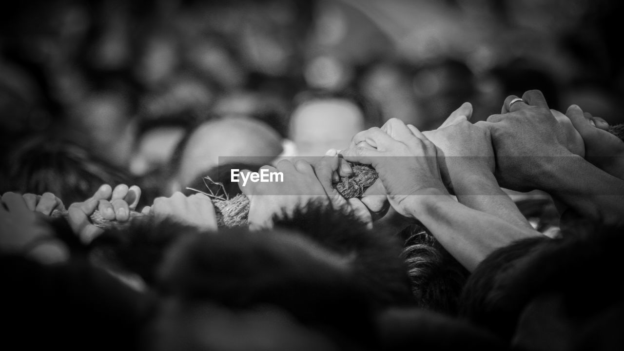 Cropped hands of people holding rope