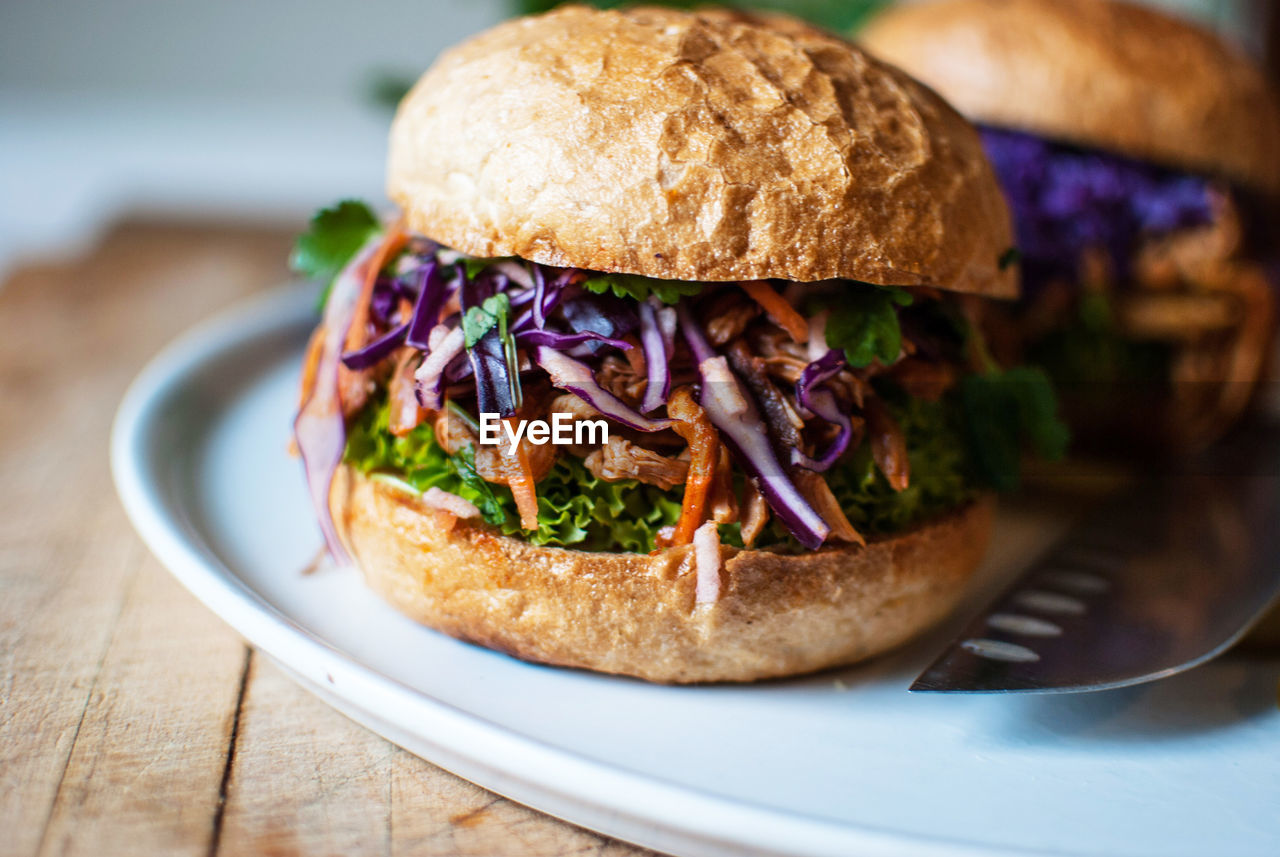 Close-up of burgers served in plate on wooden table