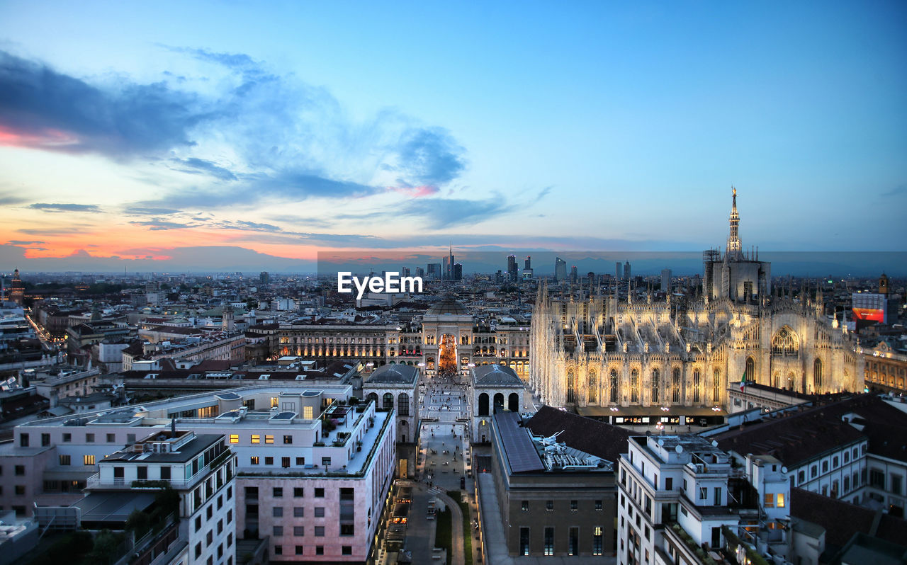 High angle view of illuminated city against sky during sunset