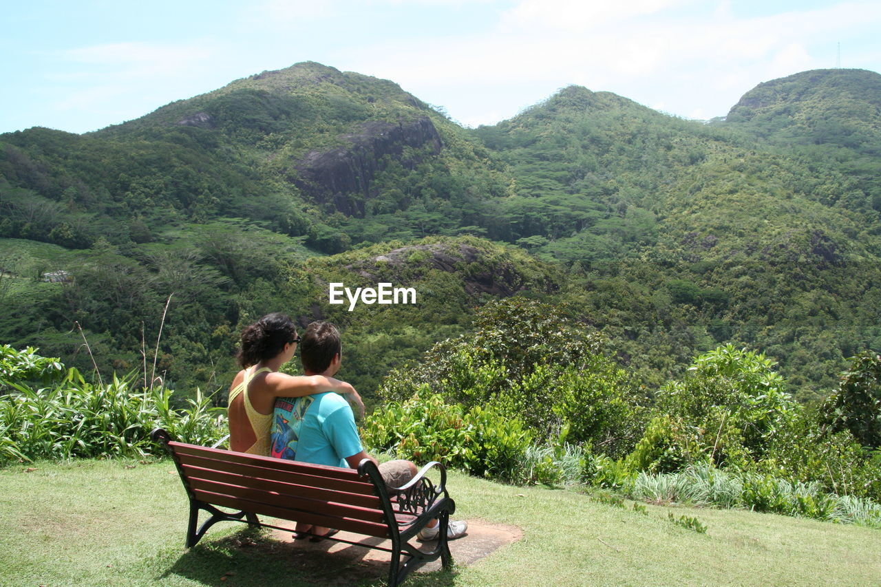 Young couple watching tropical rainforest from elevated spot