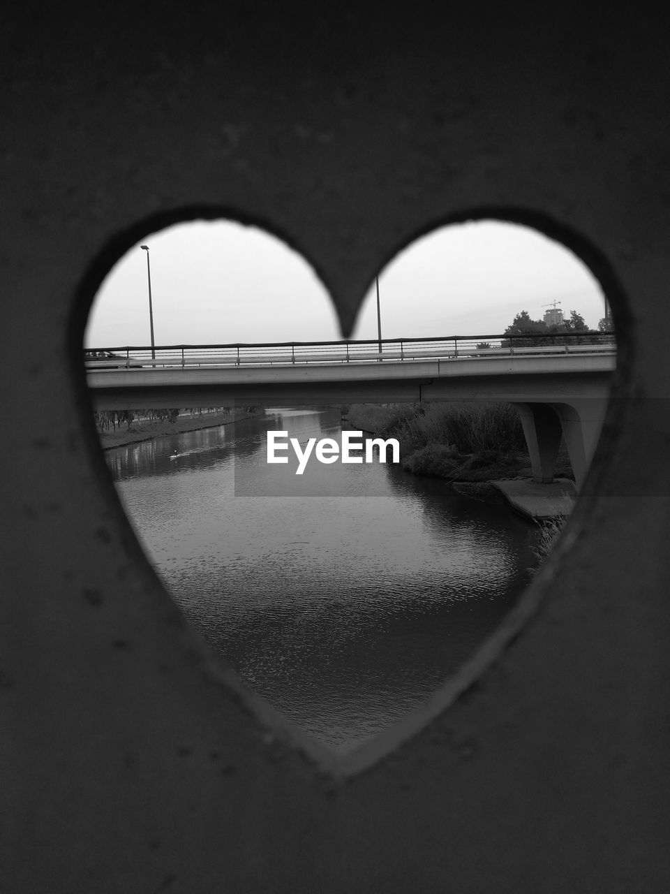 REFLECTION OF BRIDGE IN WATER AGAINST SKY