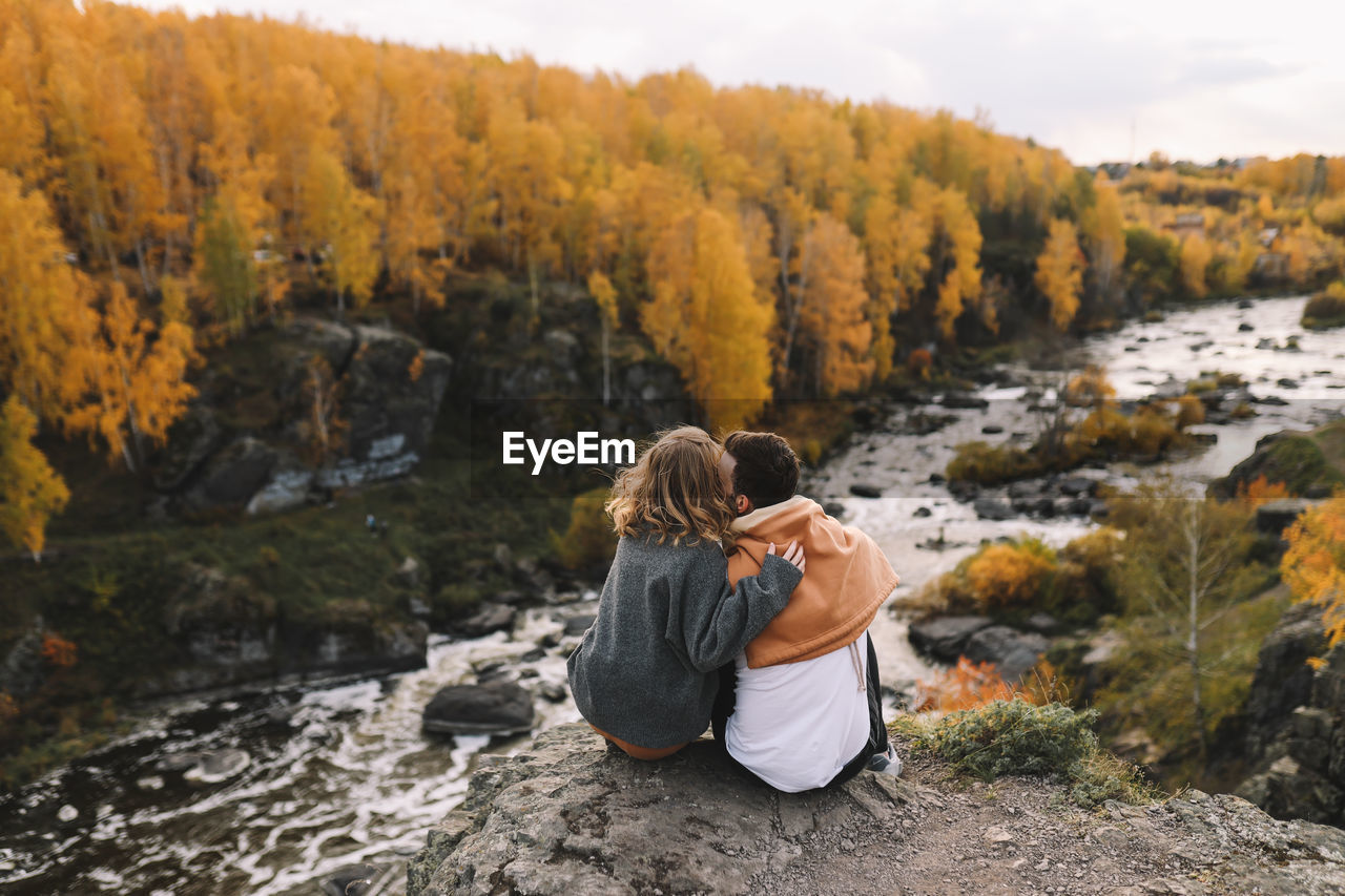 Happy people in love are travel hike in nature in the autumn forest. romantic trip to countryside