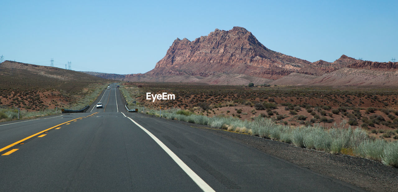 ROAD BY MOUNTAINS AGAINST CLEAR SKY