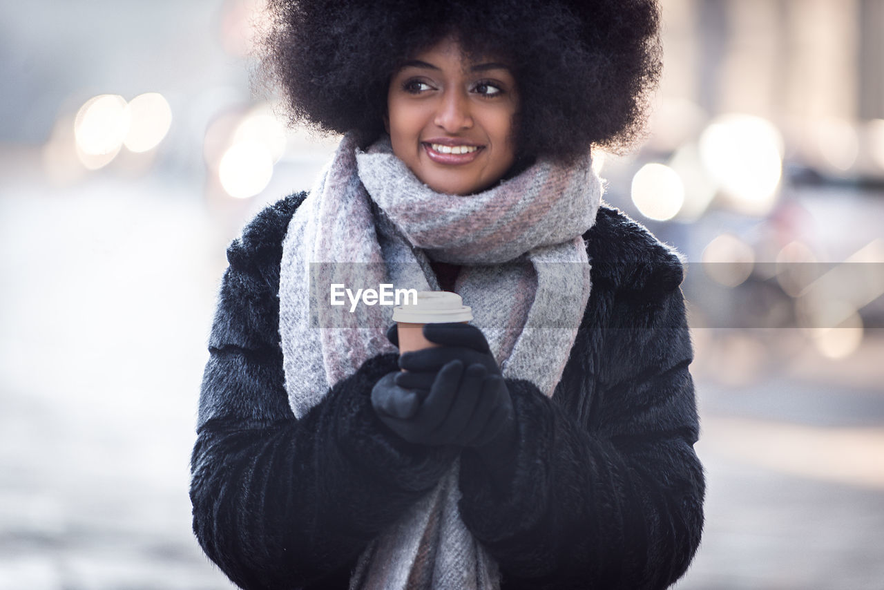 Portrait of smiling woman standing in snow