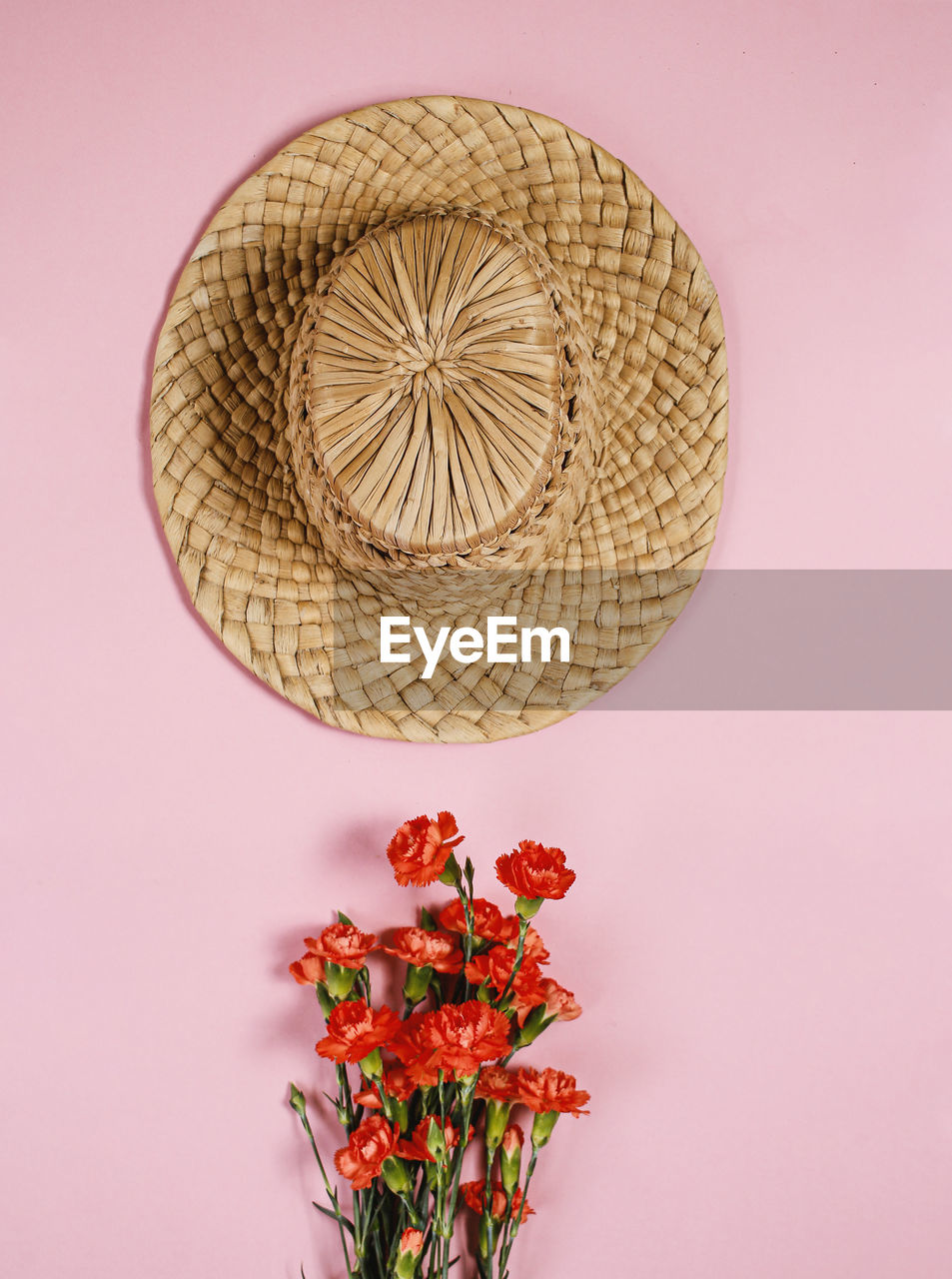 Vintage hat on pink background with flower bouquet