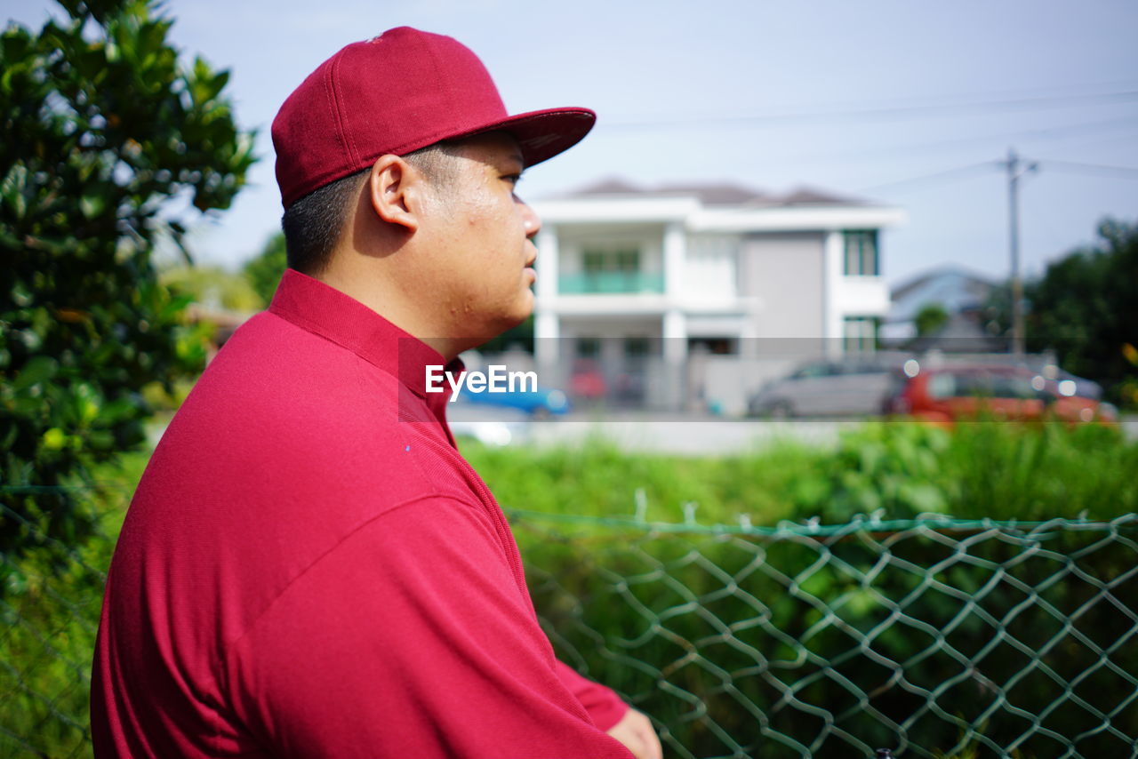 Side view of young man looking away outdoors