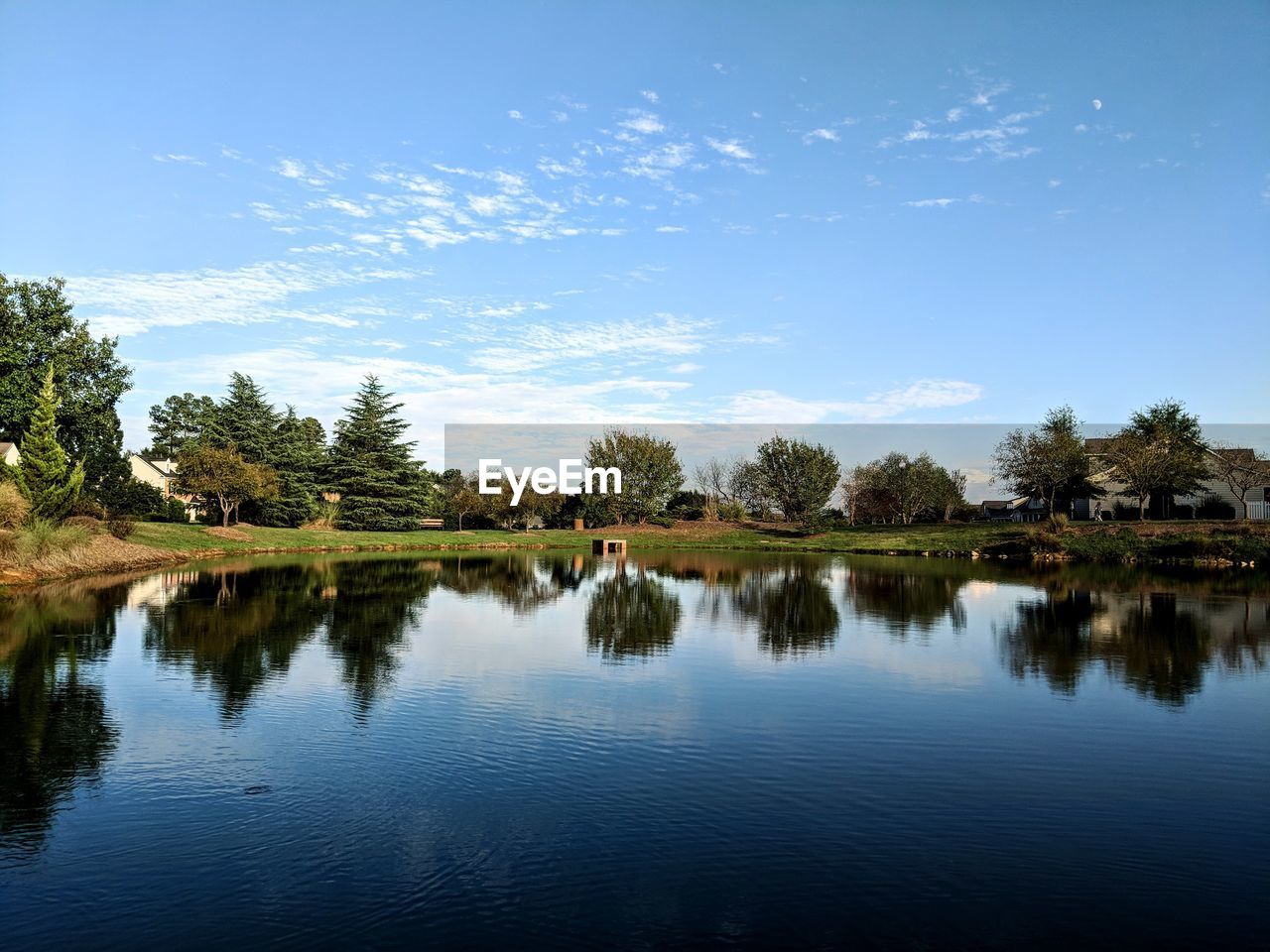 REFLECTION OF TREES IN LAKE AGAINST SKY