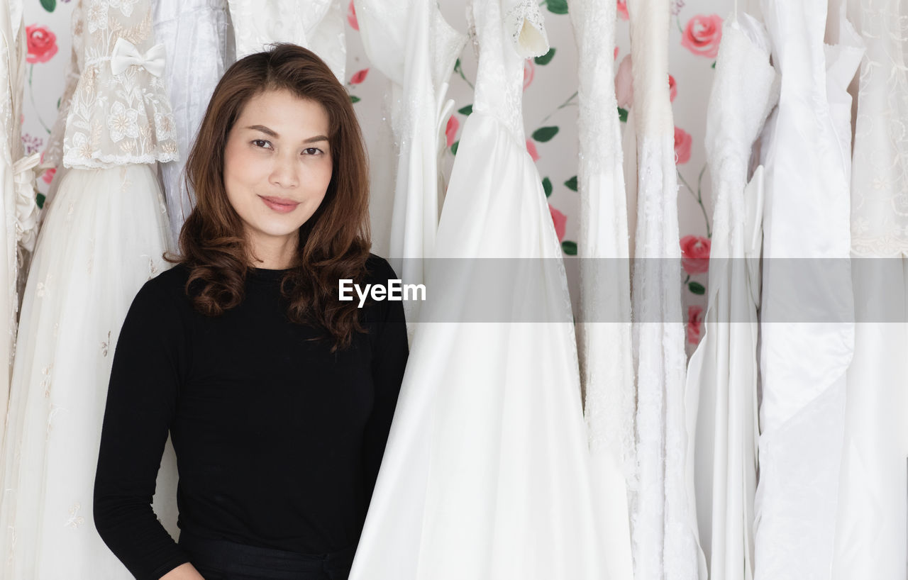 PORTRAIT OF BEAUTIFUL YOUNG WOMAN STANDING AT HOME