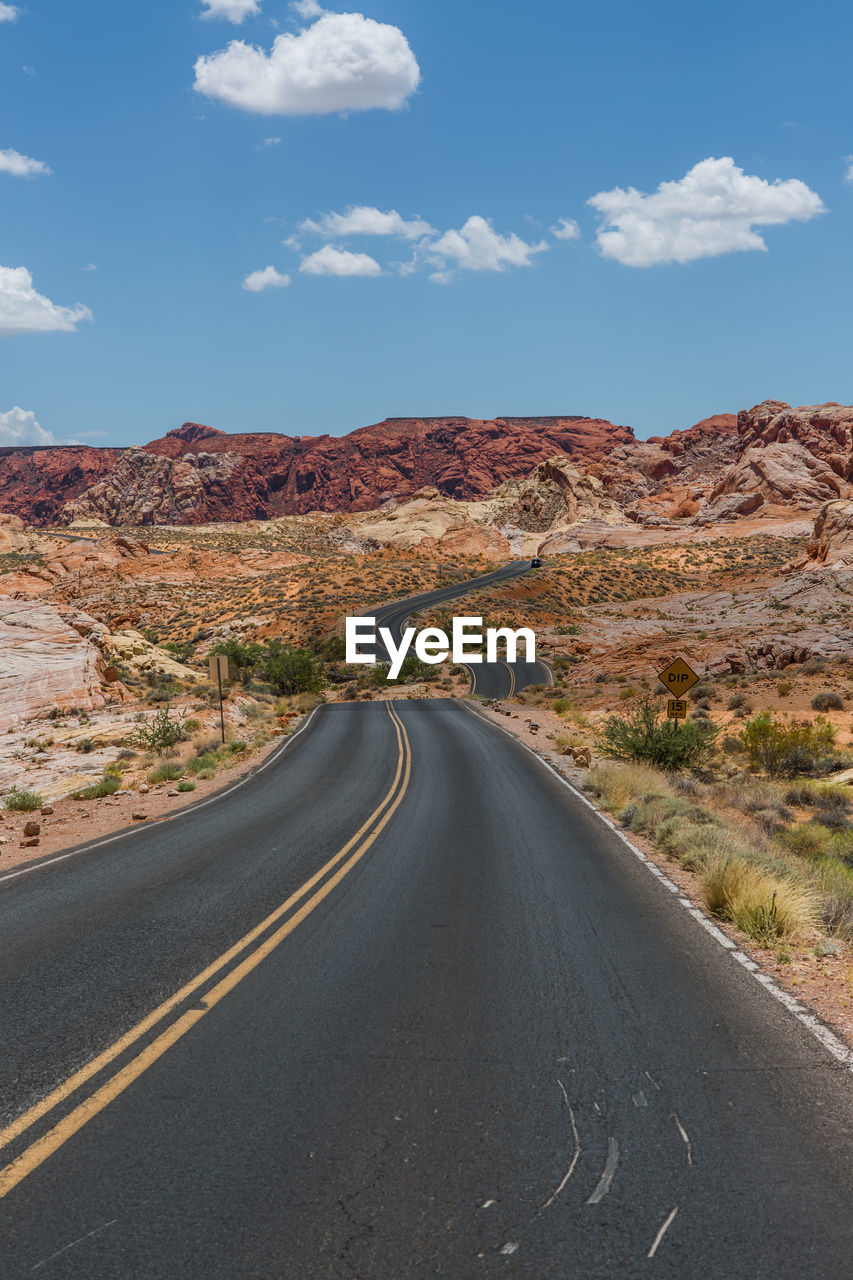 Road towards mountain against sky