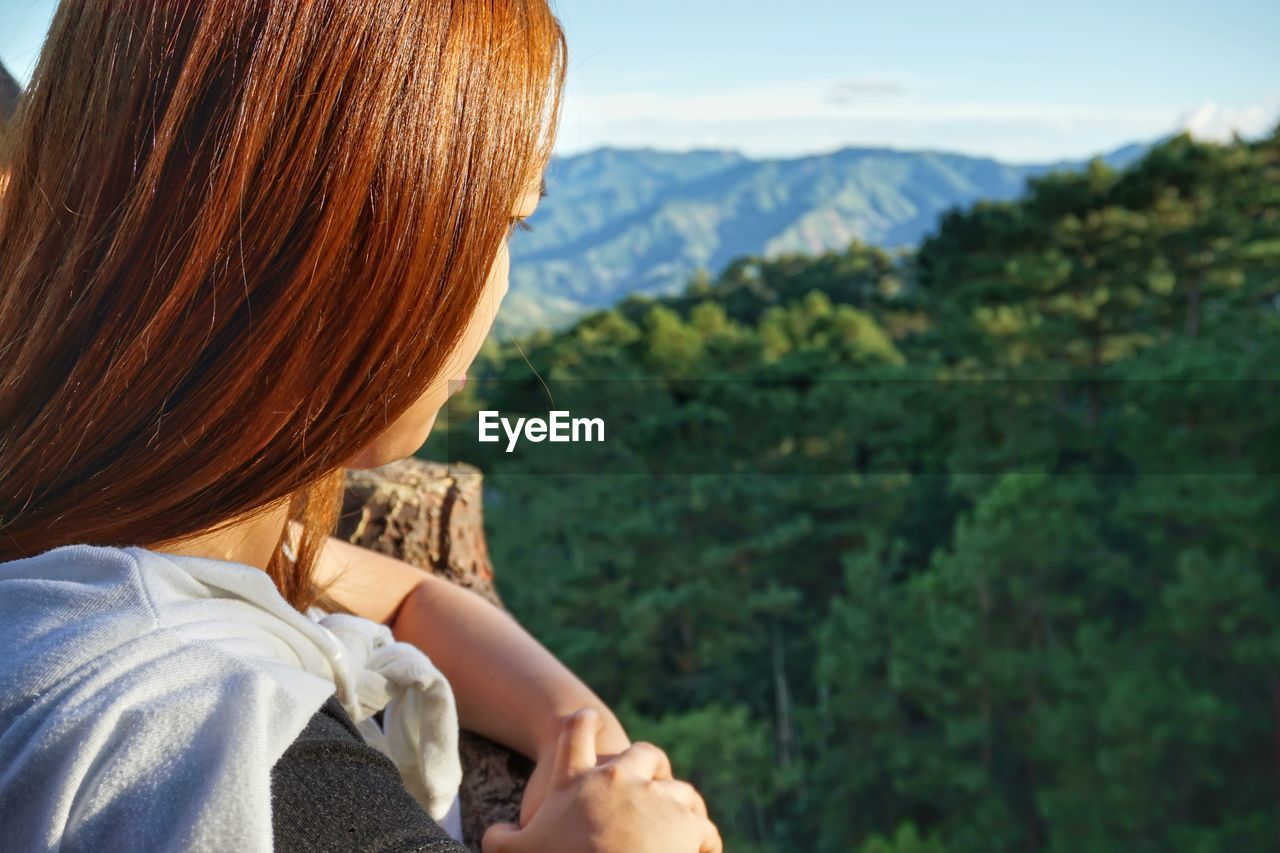 Close-up of woman against mountains and sky