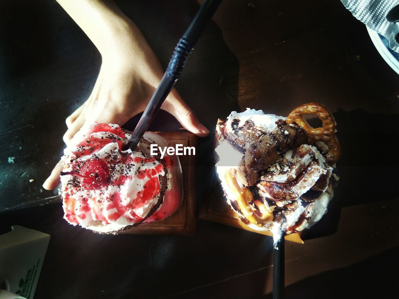 CLOSE-UP OF HAND HOLDING CAKE