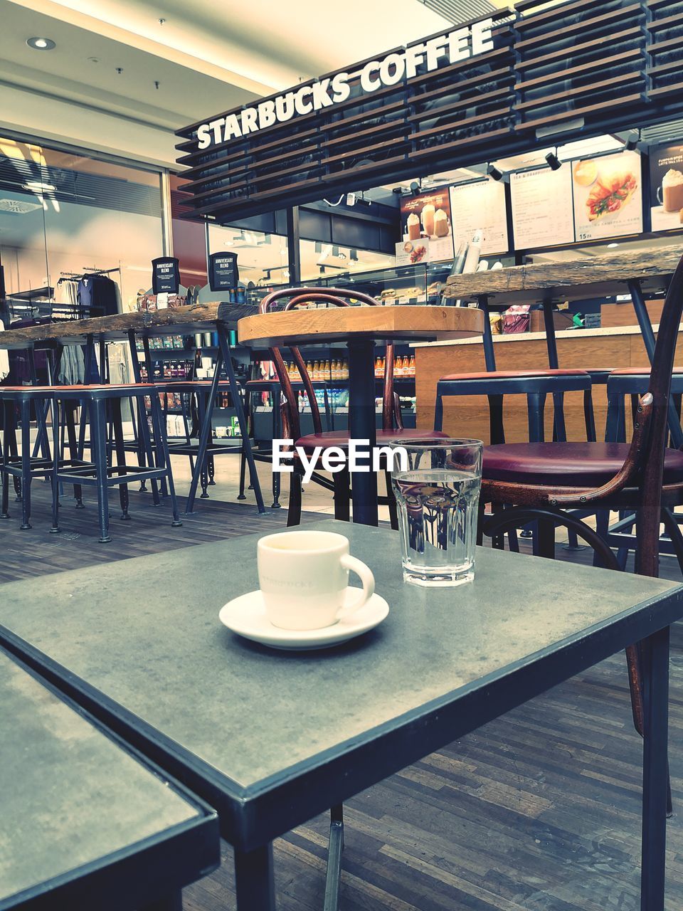 EMPTY CHAIRS AND TABLE AT CAFE