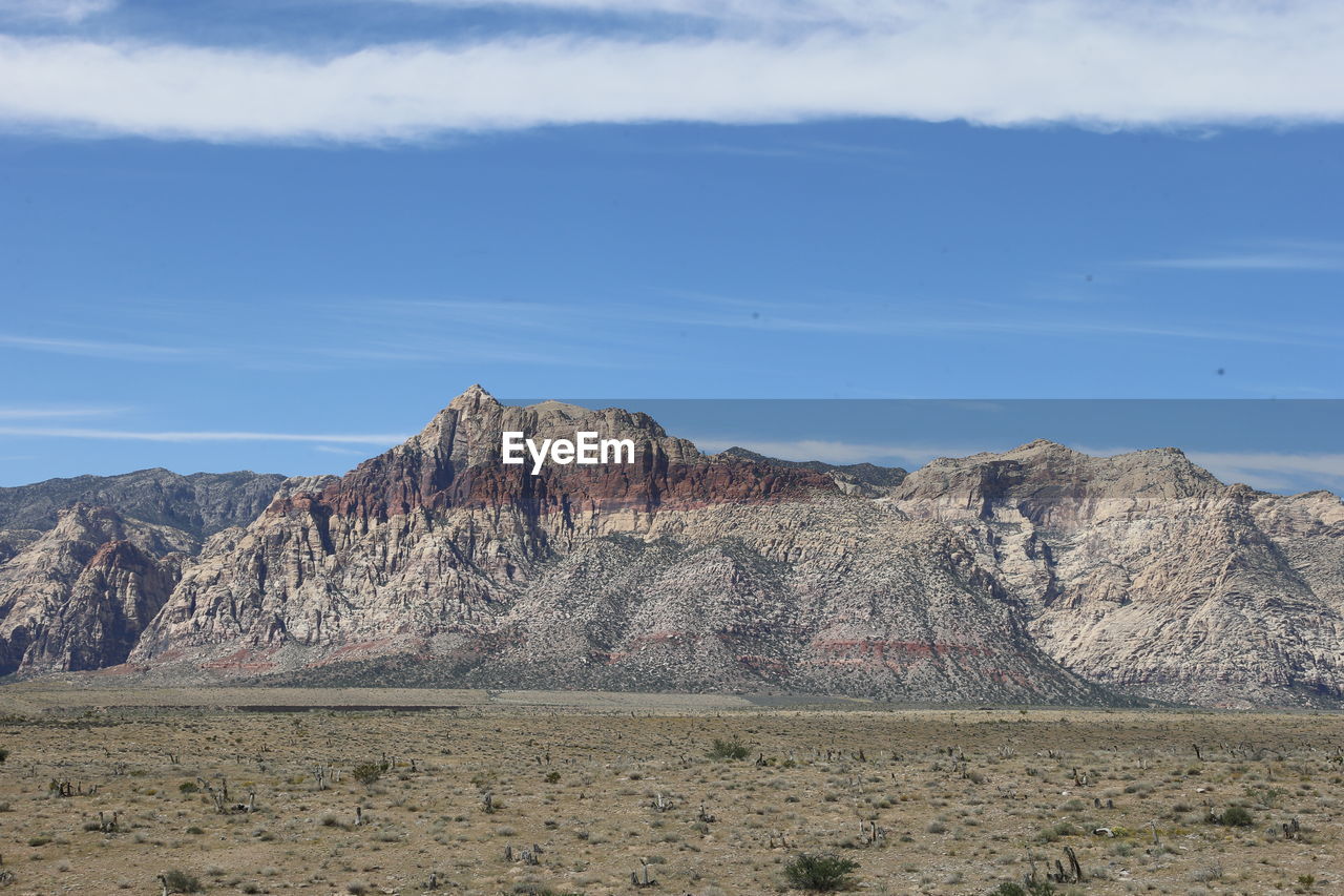 SCENIC VIEW OF ARID LANDSCAPE AND MOUNTAINS AGAINST SKY