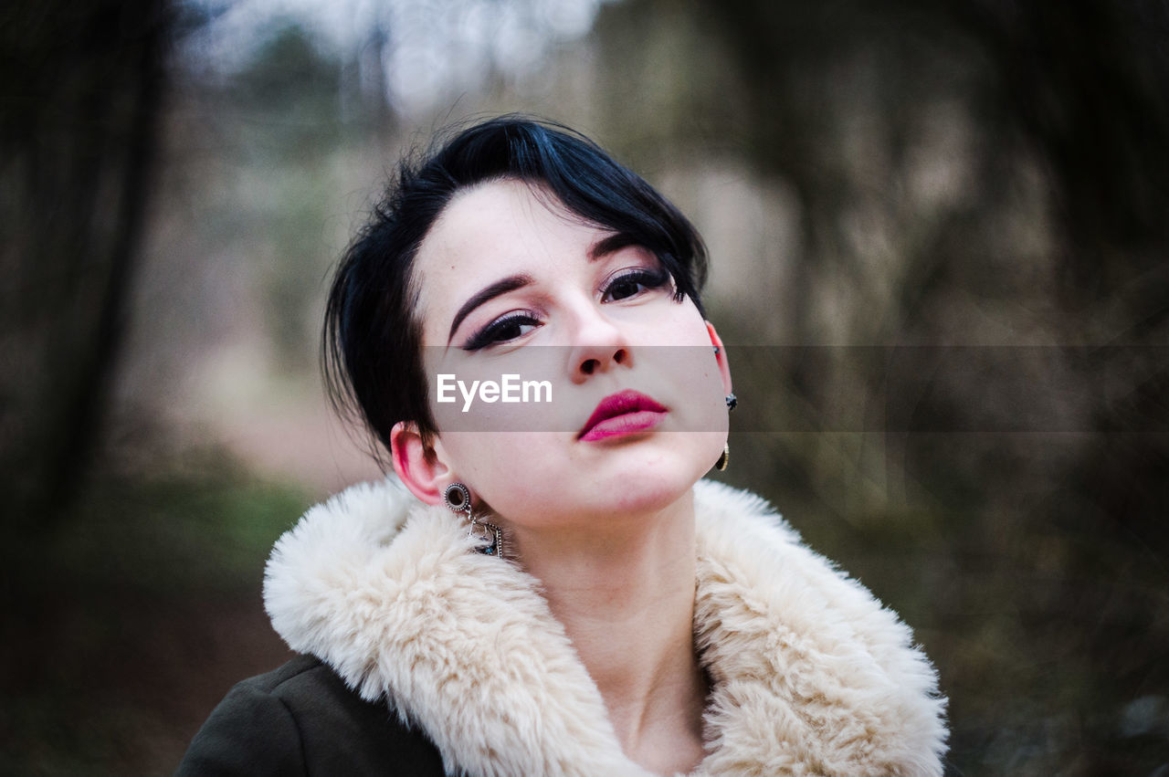 Portrait of woman wearing pink lipstick in forest