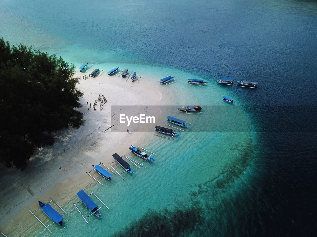 Aerial view of sailboats moored at island in sea