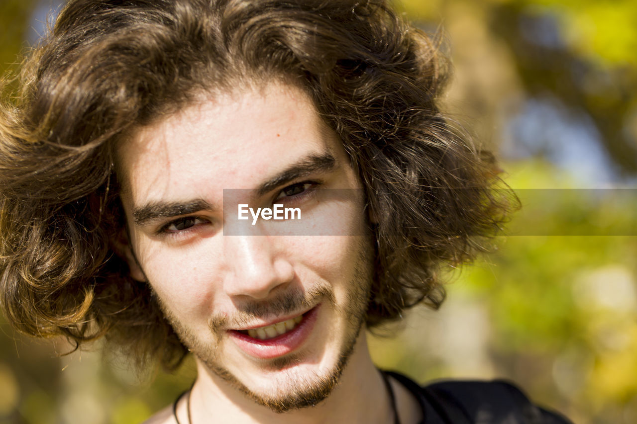 Close-up portrait of young man standing in forest