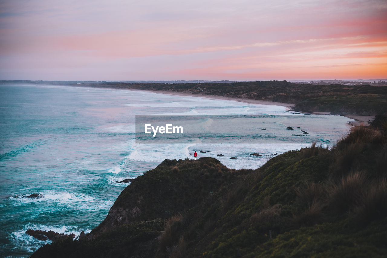 Scenic view of sea against cloudy sky during sunset