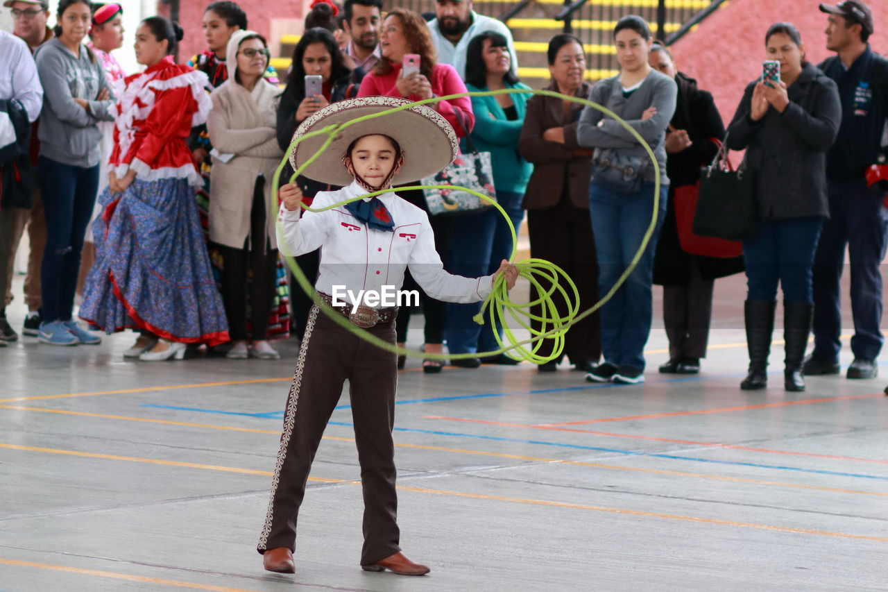 REAR VIEW OF PEOPLE STANDING ON FLOOR AT FESTIVAL