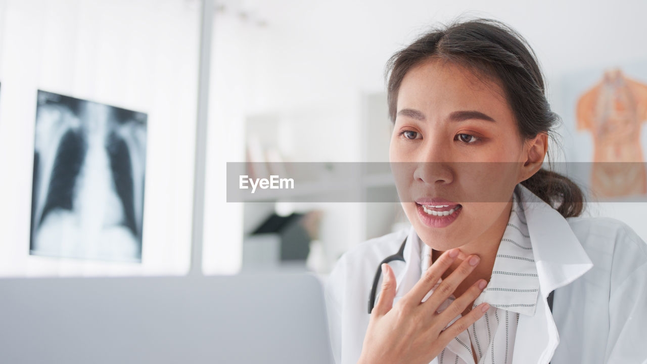 PORTRAIT OF A SMILING YOUNG WOMAN USING PHONE