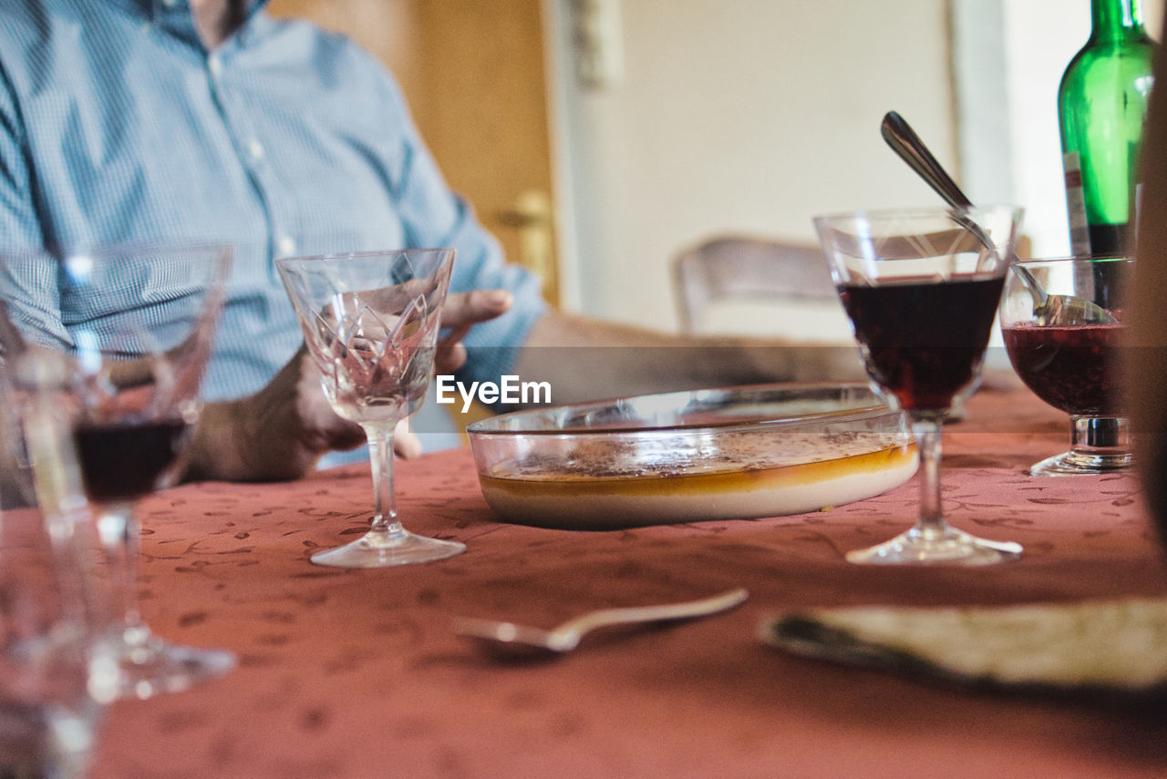 Midsection of drinking glasses on table at restaurant