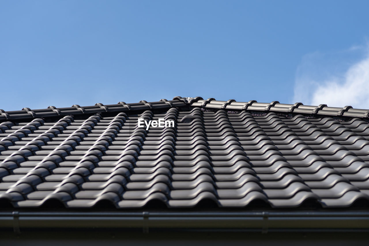 The roof of a house covered with a new ceramic tile, visible ceramic ventilation tile on the roof.