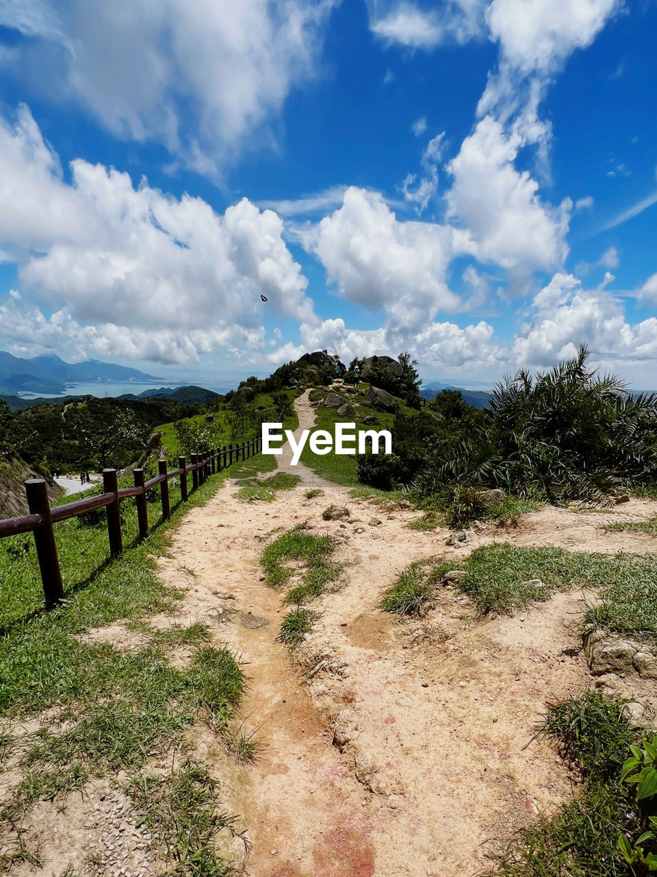 sky, cloud, landscape, environment, nature, scenics - nature, land, plant, beauty in nature, footpath, hill, rural area, no people, travel, travel destinations, tranquility, non-urban scene, sea, grass, tree, tourism, outdoors, blue, tranquil scene, coast, road, day, water, fence, the way forward, summer, rural scene, sunlight, dirt road, architecture