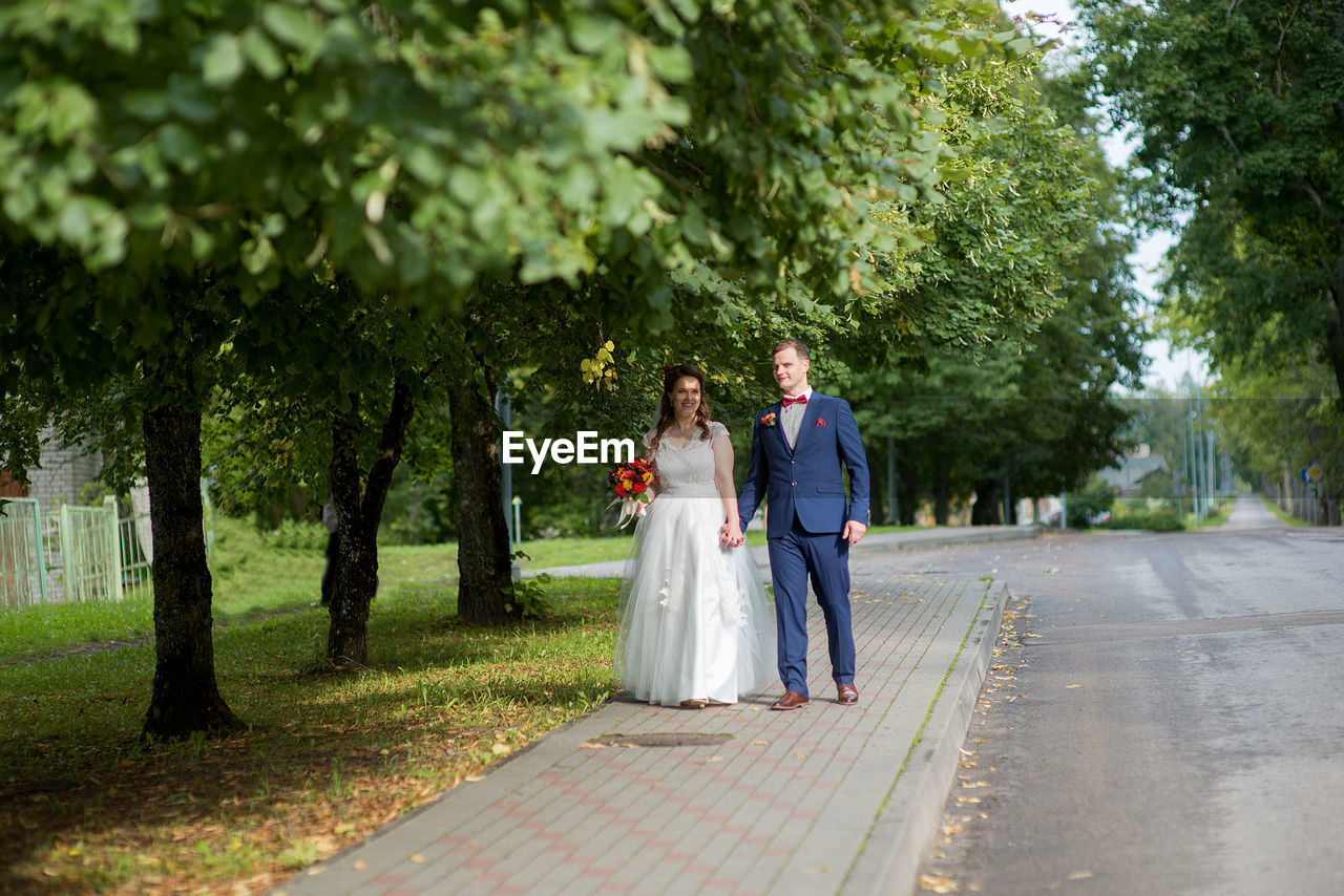 Bride and groom walking at park